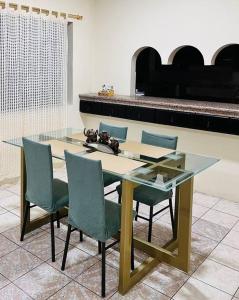a glass table with four chairs and a piano at Amplia, independiente y segura vivienda de 2 habitaciones in Machala