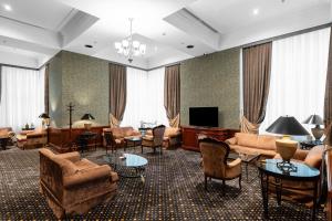 a large living room with furniture and a television at AZIMUT Grand Hotel Tashkent in Tashkent