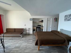 ein Wohnzimmer mit 2 Betten und eine Küche in der Unterkunft Bonita Suite Torres Gemelas in Acapulco