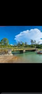 un ponte su un fiume con una barca in acqua di The Mangrove a Sematan