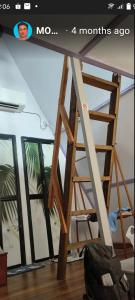 Una escalera de madera en una habitación con ventana en The Mangrove, en Sematan