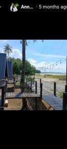 Blick auf einen Strand mit einem Baum und einer Holzterrasse in der Unterkunft The Mangrove in Sematan