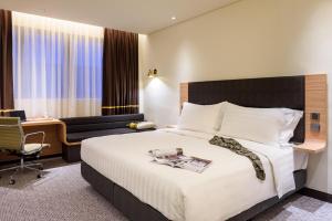 una camera d'albergo con un letto e una scrivania di Camlux Hotel a Hong Kong