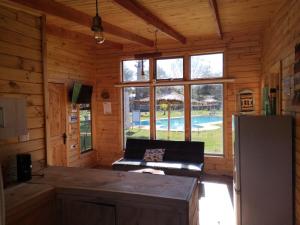 a kitchen and living room of a log cabin at Rukawe Quillon in Quillón