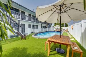 a wooden table with an umbrella next to a pool at 2BR Cozy FLL Retreat! in Fort Lauderdale
