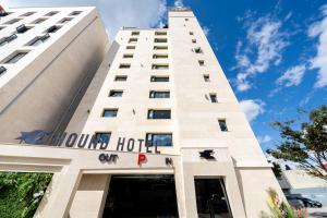 木浦的住宿－Hound Hotel Mokpo Peace Plaza，上面标有酒店标志的高大的白色建筑