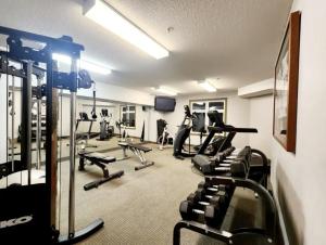 a gym with several treadmills and cardio machines at NEW! Central Canmore- Light Industrial Hotel Room in Canmore