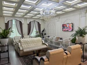a living room with couches and a chandelier at Ideal Hotel in Samarkand