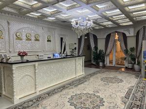 a large room with a chandelier and a marble counter at Ideal Hotel in Samarkand