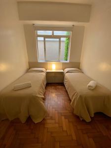 2 Betten in einem kleinen Zimmer mit Fenster in der Unterkunft Apartamento Malabia in Buenos Aires