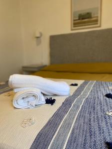 una pila de toallas blancas en una cama en Apartamento Malabia en Buenos Aires
