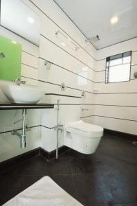 a bathroom with a white toilet and a sink at Cherryleen Resort Nagaon in Nagaon