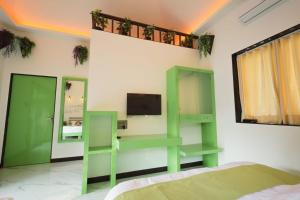 um quarto com prateleiras verdes e uma televisão na parede em Cherryleen Resort Nagaon em Nagaon