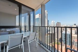 a balcony with a table and chairs and a view of the city at Queen St Residence in Brisbane