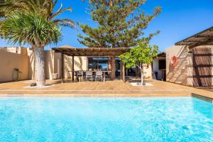 a swimming pool in front of a house with a gazebo at Villa Santana in Conil