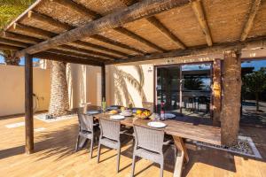 an outdoor dining area with a wooden table and chairs at Villa Santana in Conil