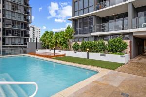 a swimming pool in front of a building at Hearty Milton Apartments in Brisbane