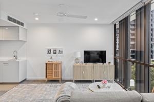 Hearty Milton Apartments في بريزبين: غرفة معيشة مع أريكة وتلفزيون
