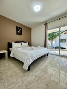 a bedroom with a large bed and a large window at Fundee Resort in Chanthaburi