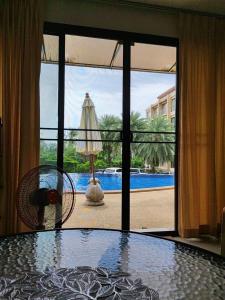 Cette chambre dispose d'une table et offre une vue sur la piscine. dans l'établissement Apartment, à Ban Mae Nam