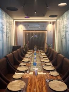 a long table in a room with chairs at Hotel Samudyatha Inn And Suites in Kundapur