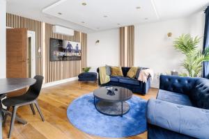 ein Wohnzimmer mit einem blauen Sofa und einem Tisch in der Unterkunft First Class Living Experience Luxury In Harley St in London