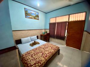 Un dormitorio con una cama con un osito de peluche. en Sawitri Homestay en Padangbai