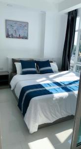 a blue and white bed in a room with a window at 一室一厅宁静舒适公寓清迈市中心 in Chiang Mai