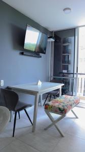 una mesa con TV en la pared en una habitación en VILLAVICENCIO! Increíble, Hermoso y moderno APARTAMENTO COMPLETO, con PISCINA! en Villavicencio
