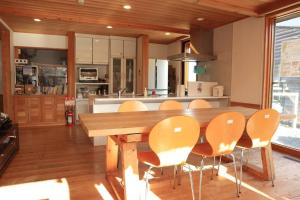 uma cozinha com uma mesa de madeira e cadeiras em 都留市エコハウスで移住体験を em Tsuru 
