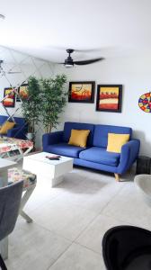 比亞維森西奧的住宿－VILLAVICENCIO! Increíble, Hermoso y moderno APARTAMENTO COMPLETO, con PISCINA!，客厅配有蓝色的沙发和黄色的枕头。