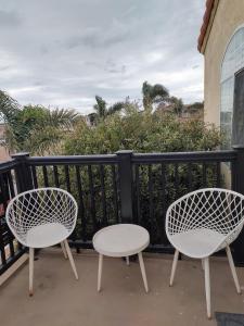 two white chairs and a table on a balcony at Pacific Plaza Resort in Oceano