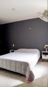 1 dormitorio con 1 cama grande y pared negra en VILLAVICENCIO! Increíble, Hermoso y moderno APARTAMENTO COMPLETO, con PISCINA! en Villavicencio
