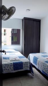 um quarto com 2 camas e uma grande janela em VILLAVICENCIO! Increíble, Hermoso y moderno APARTAMENTO COMPLETO, con PISCINA! em Villavicencio