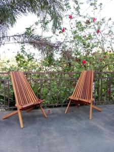 dois bancos de madeira sentados em frente a uma cerca em The Chill River-Boutique Villa em Siem Reap