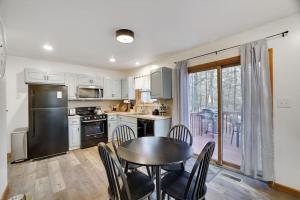 a kitchen with a table and a table and chairs at 15 Min to Ski Resorts, Dog Friendly, Cozy 3 BR, Game Area & Fire Pit in East Stroudsburg
