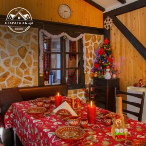 ein Esszimmer mit einem Weihnachtstisch und einem Weihnachtsbaum in der Unterkunft СТАРАТА КЪЩА in Sovolyano