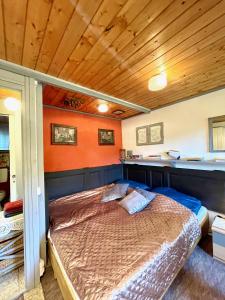 1 dormitorio con 1 cama con pared de color naranja en Juhfark Apartman Varsádi Wineyard en Somlóvásárhely