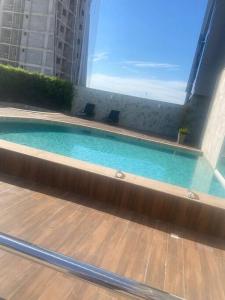 a swimming pool in a building with chairs in it at Ap novo em frente a shopping center e próximo a praia in Vila Velha