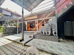 un edificio con un mural de árbol en el costado en Sawitri Homestay en Padangbai