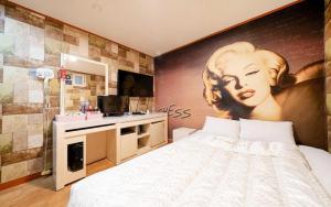 a bedroom with a bed with a painting on the wall at Chess Motel in Seoul