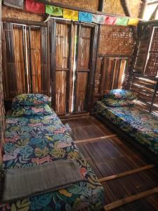 Duas camas num quarto com pisos em madeira em WaitHozz em Beran-kidul