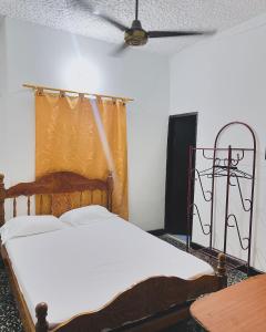 een slaapkamer met een bed en een plafondventilator bij Hotel Costa Norte in Santa Marta