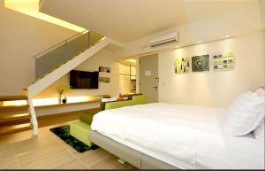 ein Schlafzimmer mit einem großen weißen Bett und einer Treppe in der Unterkunft Liu Yuan Green Villa in Taitung