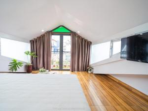 un soggiorno con una grande finestra e una TV a schermo piatto di Khách Sạn Lối Về Đà Lạt a Da Lat