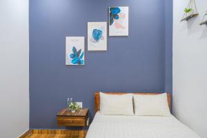 una camera da letto con una parete blu, un letto e un tavolo di Khách Sạn Lối Về Đà Lạt a Da Lat