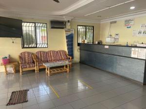 a waiting room with two chairs and a counter at OYO 90914 Hotel Mei Wah in Kampong Selanchor