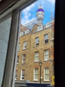 a view of a building with a tower in the background at Cozy Flat, 5 minute walk to Oxford Circus in London