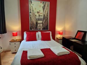een slaapkamer met een groot bed met rode muren bij Cozy Flat, 5 minute walk to Oxford Circus in Londen