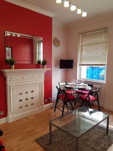 a living room with a table and chairs and a fireplace at Cozy Flat, 5 minute walk to Oxford Circus in London